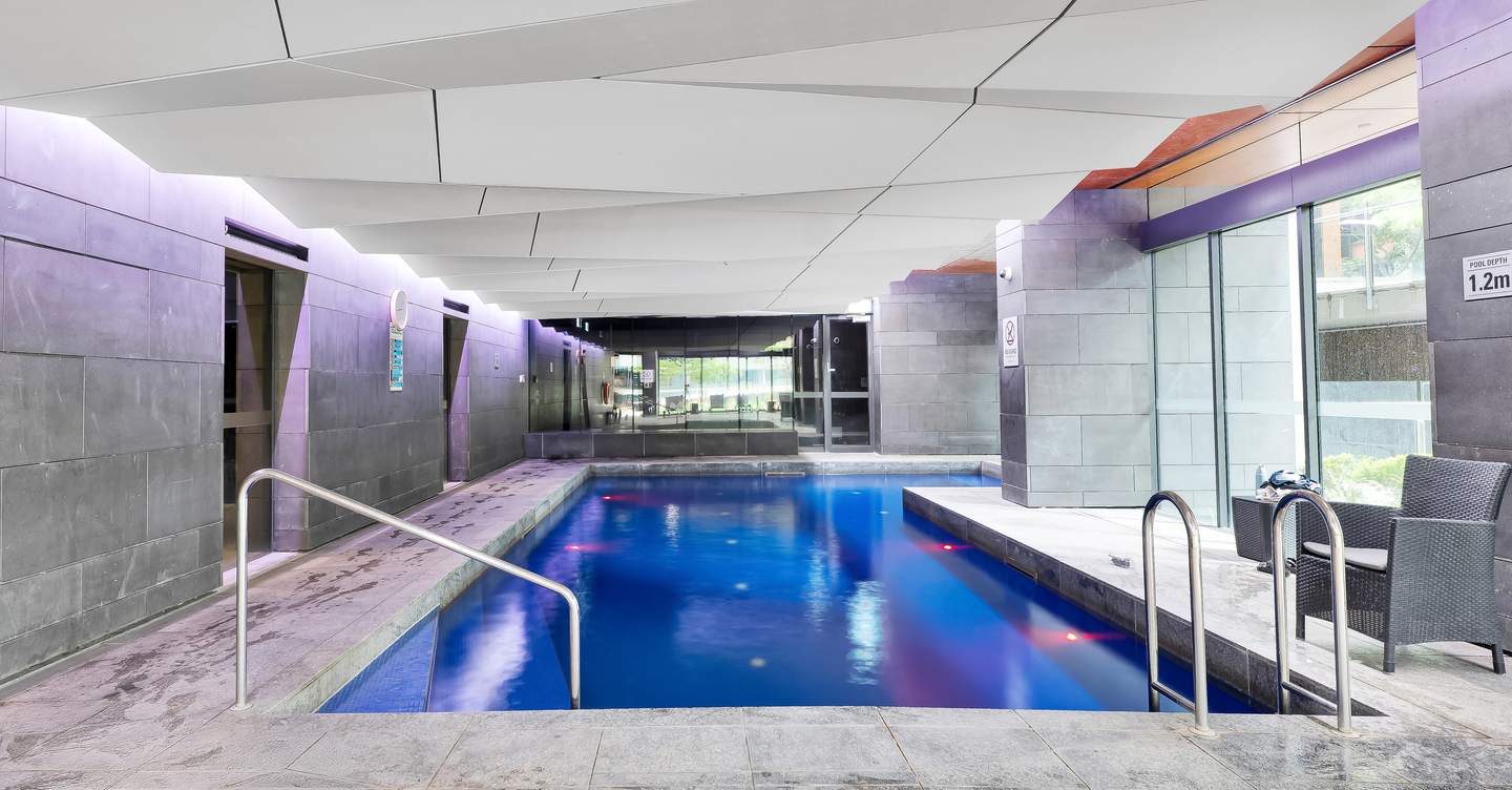 Madison: the building’s shared indoor pool — one of two heated indoor pools in the complex, open 6:00 AM to 11:00 PM