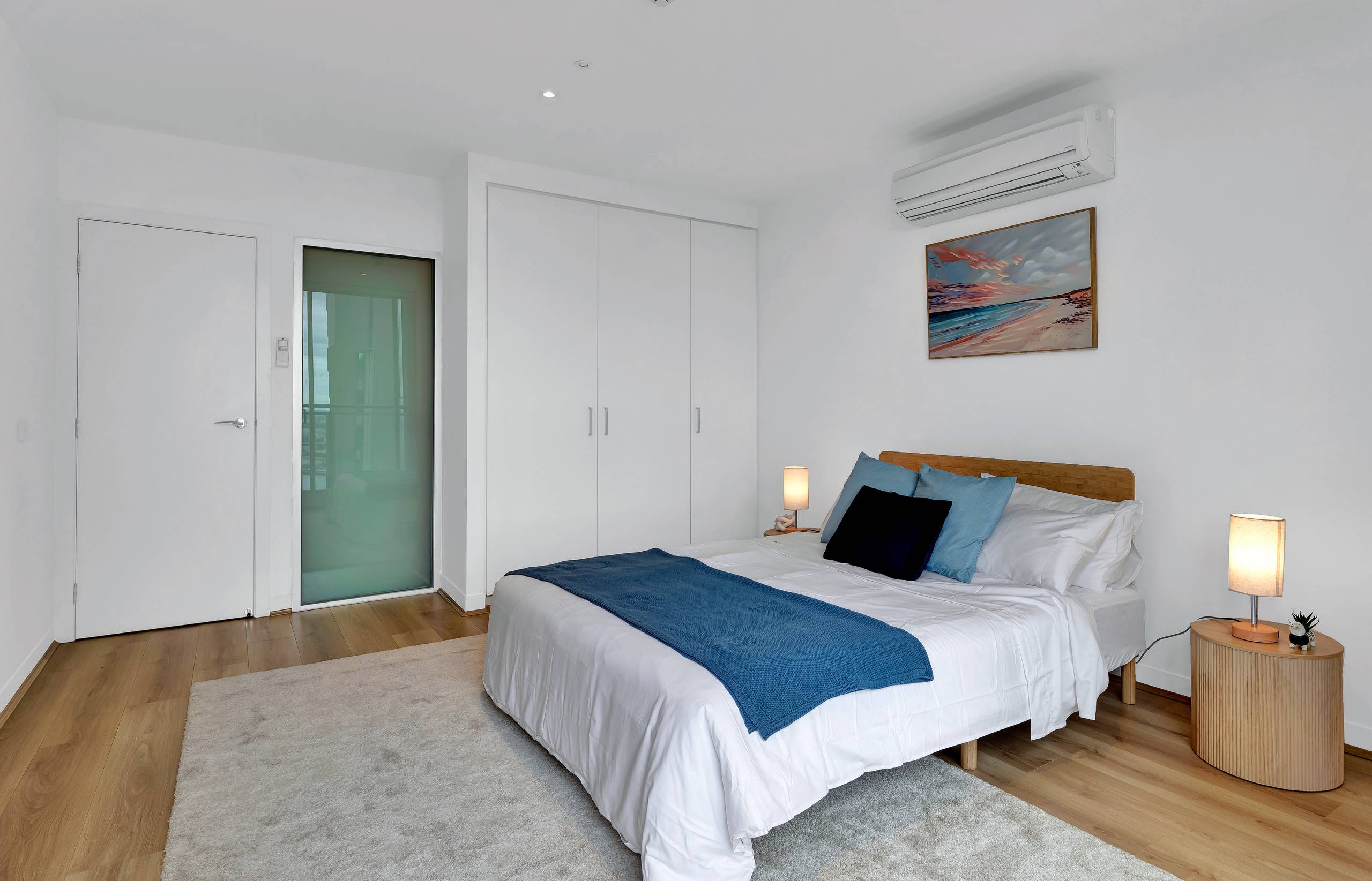 Spencer: master bedroom — full-height built-in wardrobes, with a bedside touch lamp either side of the queen bed
